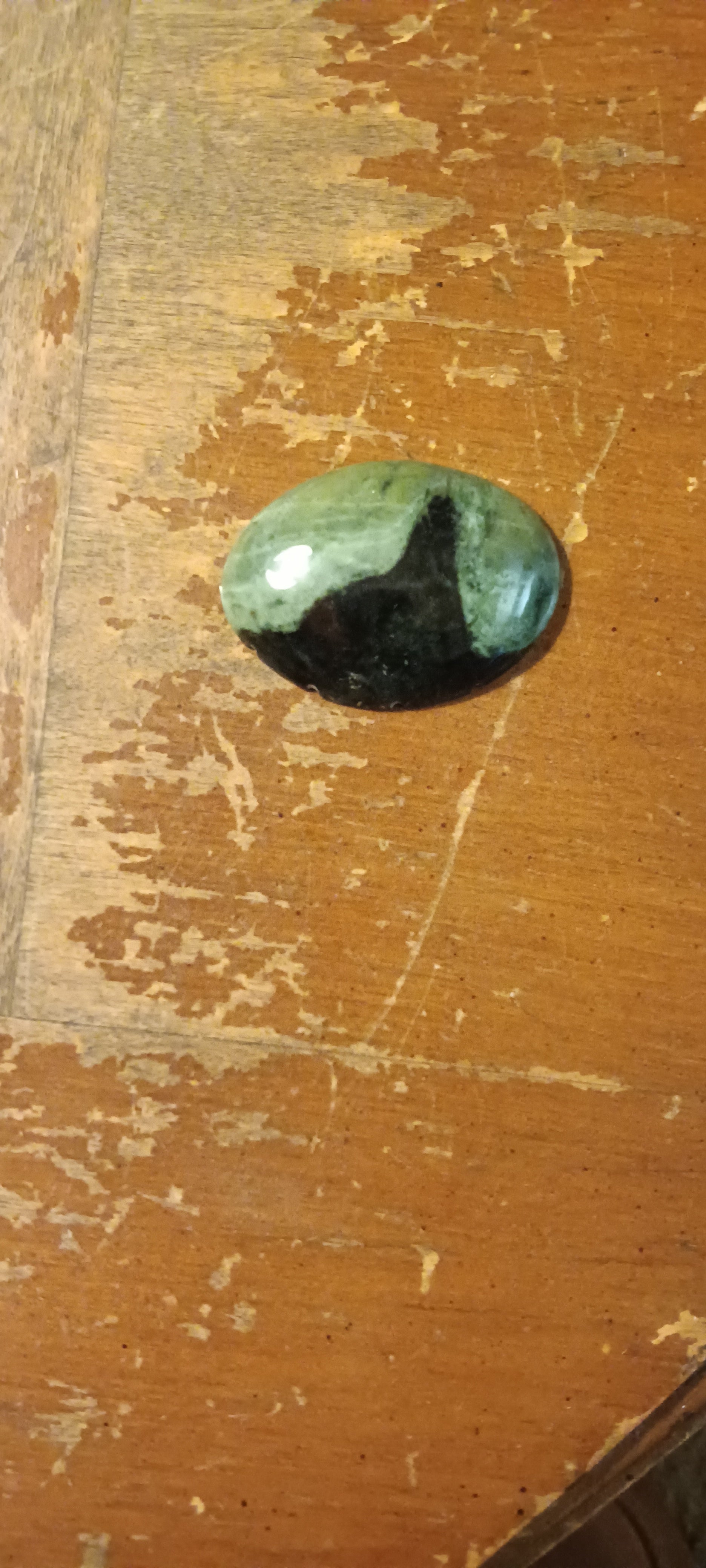 One-of-a-kind handcrafted serpentine gemstone pendant, muted forest green with subtle mottling, polished dorsal fin shape. Rockhound Studio.