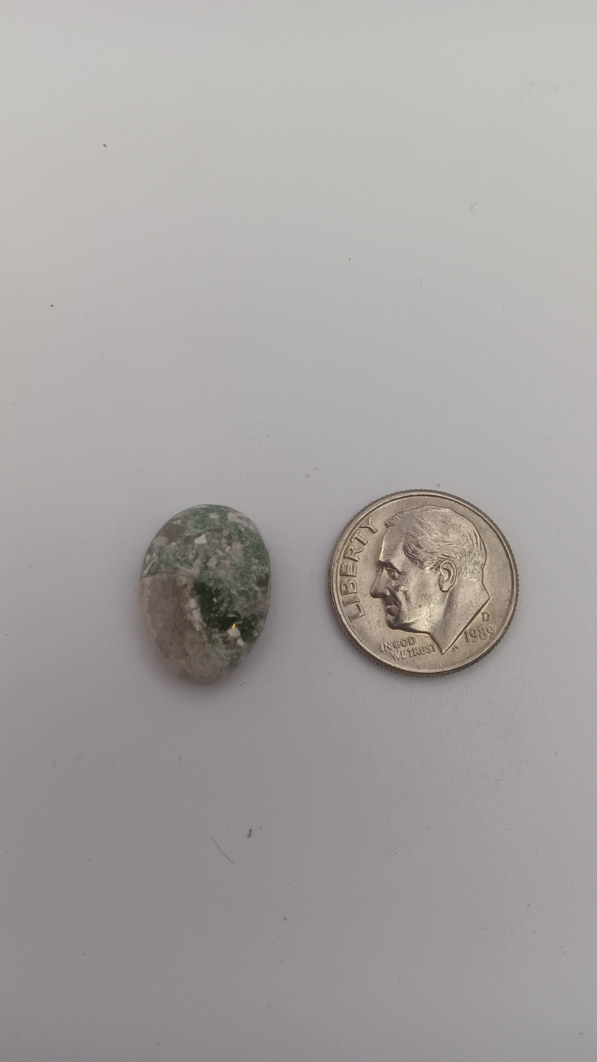 Green and white malachite oval 16mm loose cabochon size comparison with coin by Jones Stones USA