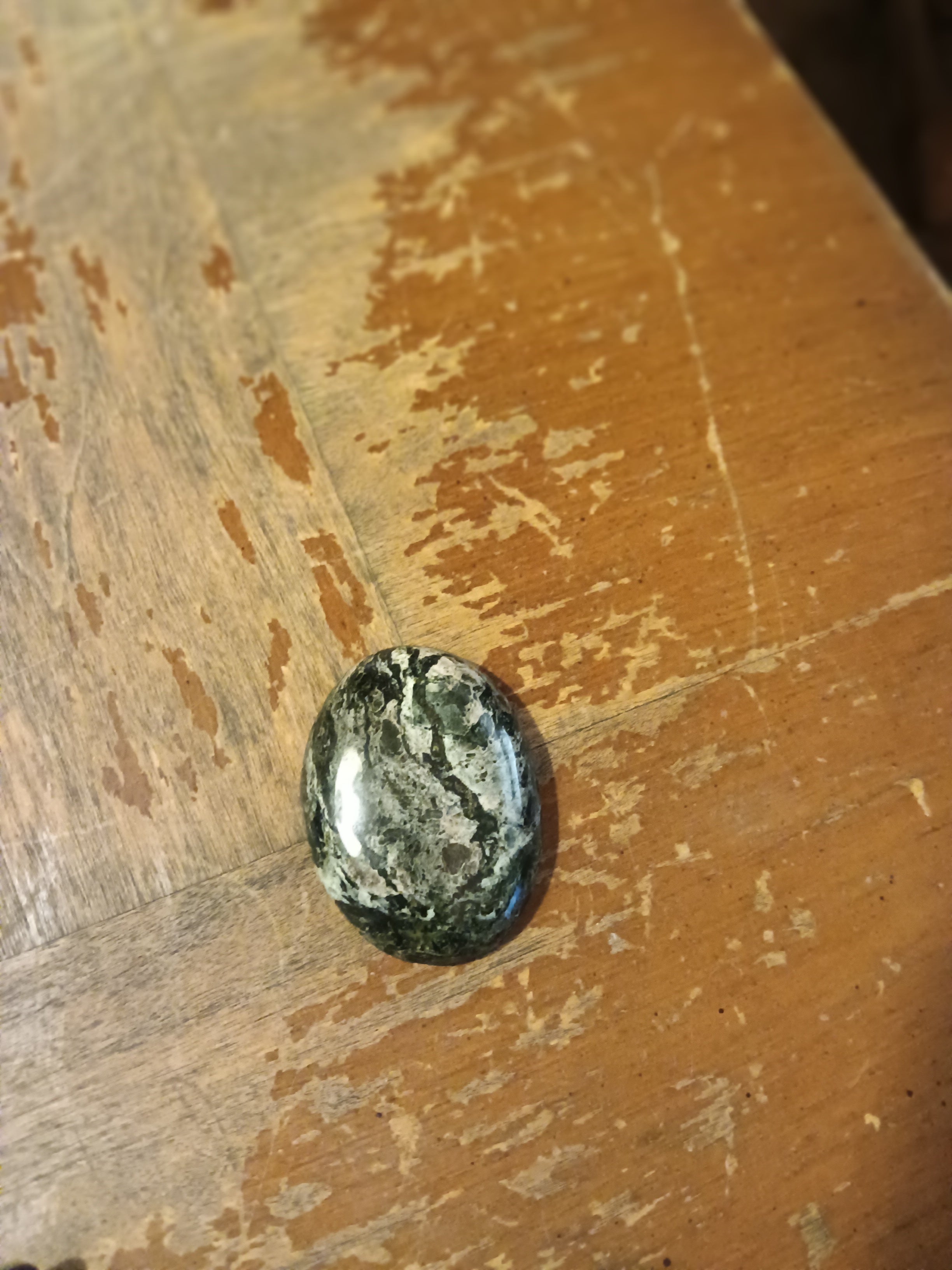 Black oval Breccia Aventurine with sharp grey-white veining, high gloss finish. Handcrafted gemstone, one of a kind. Rockhound Studio.