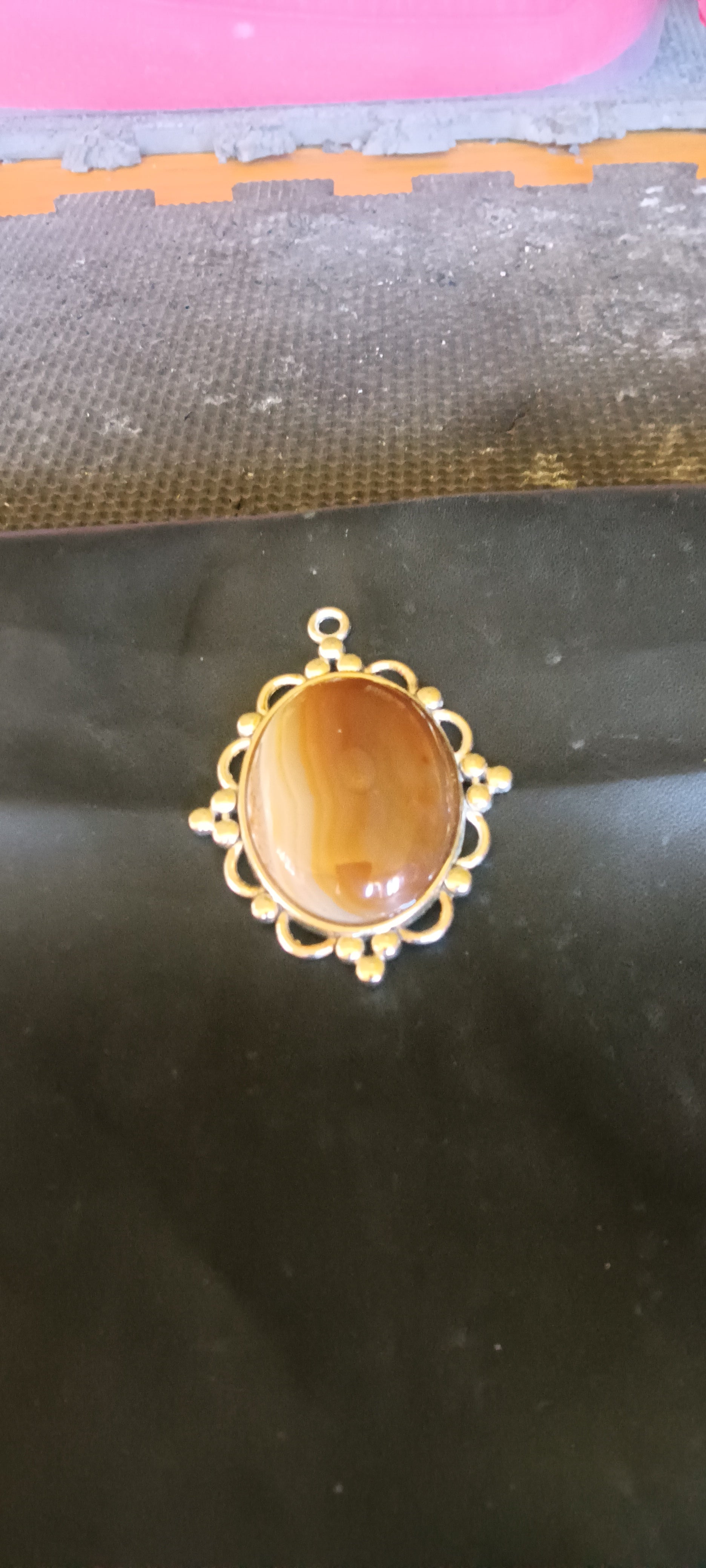 Oval, high-polish Botswana Agate gemstone pendant with caramel brown, milky white, and translucent tan bands in a silver setting, one of a kind. Rockhound Studio.